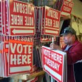 Art Hughes, a poll worker with Washington County’s Election Commission, helps load vote signs from t...
