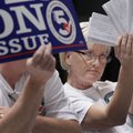 Melissa Fults, treasurer for Arkansans for Compassionate Care, holds up cards at the back of a room ...