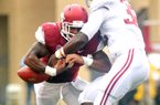 Alabama linebacker C.J. Mosley forces Arkansas running back Knile Davis to fumble in the Crimson Tide’s 52-0 victory, one of eight dropped balls by the Hogs in the game. 
