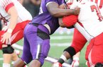 News-Times/Michael Orrell -- El Dorado defensive lineman Bijhon Jackson, purple, works a Camden Fairview offensive lineman in the Wildcats season opener at Memorial Stadium. 