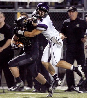 Alex Brignoni, a Fayetteville senior defensive back, brings down Bentonville senior running back Garrett Kaufman during the second half on Friday at Tiger Stadium in Bentonville. 