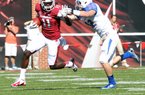 Arkansas receiver Cobi Hamilton (11) tries to fend off Tulsa defender Mitchell Osborne as he runs for 19 yards in the third quarter of Saturday’s game at Reynolds Razorback Stadium in Fayetteville.