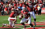 Running back Dennis Johnson (33) scores Arkansas’ first touchdown, an 8-yard run in the first quarter, as tight end Alex Voelzke (46) and wide receiver Javontee Herndon (19) celebrate. Johnson, who rushed for 109 yards on 22 carries, also scored Arkansas’ final touchdown from a yard out to seal the 19-15 victory over Tulsa. Johnson, a fifth-year senior from Texarkana, has consecutive 100-yard games for the first time as a Razorback.