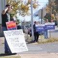 Joel Keller, from left, Mike Carney and Jim Murawski hold political signs Thursday outside of an ear...