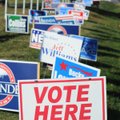A “Vote Here” sign is mixed in with all the political signs at the entrance to Parsons Stadium on Th...