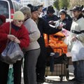 Residents line up for bundles of food at an American Red Cross station in the Coney Island section o...