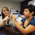 McKensie Collins, a sophomore, left, and Reina Castillo, a junior, work on making a bracelet in thei...