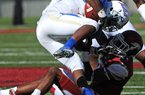 Arkansas’ Demetrius Wilson (right) pulls down Tulsa’s Trey Watts during Arkansas’ 19-15 victory Saturday. Watts rushed for 81 yards and had 2 catches for 53 yards.