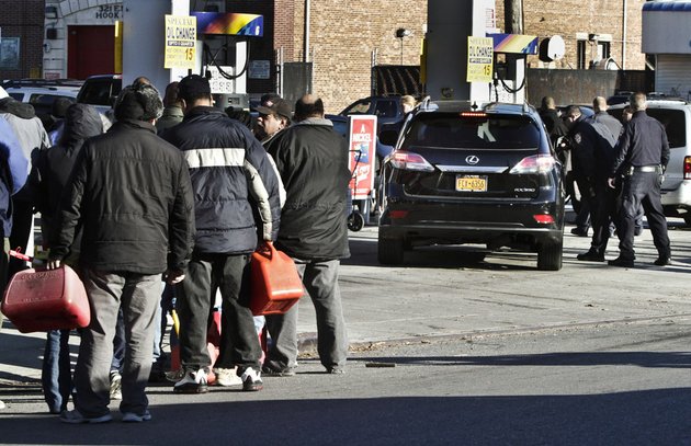 police-direct-cars-to-pumps-while-people-stand-in-line-with-containers-for-gas-on-friday-nov-9-2012-in-the-brooklyn-borough-of-new-york-police-were-at-gas-stations-to-enforce-a-new-gasoline-rationing-plan-that-lets-motorists-fill-up-every-other-day