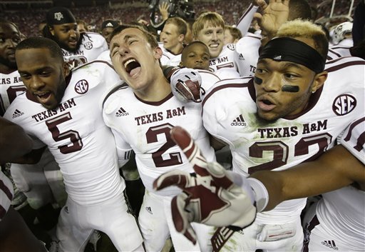 Texas A&M quarterback Johnny Manziel (2) is joined by wide receiver Kenric McNeal (5) and defensive back Dustin Harris (22) as they celebrate a win over top-ranked Alabama at Bryant-Denny Stadium in Tuscaloosa, Ala., Saturday, Nov. 10, 2012. This year's game is at the top of a list for most expensive tickets for the 2013 college football season that U.S. Presswire released. (AP Photo/Dave Martin)