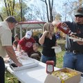 Cody Anglin of Bentonville enjoys a free hot dog lunch Saturday at the dedication of the new Austin-...