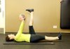 Nancy Jeffery contracts her abdominals to prevent her lower back from moving as her legs come up for the Straight Leg Scissors With Medicine Ball. 