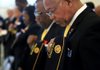 R.D. Kinsey (right) and John Sanders of American Legion Post 74 in North Little Rock bow their heads during the benediction Sunday at the Veterans Day ceremony at the state Capitol. 