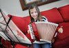 AnnieBeth Mabry, a third-grader at Turnbow Elementary School, holds on Thursday the accordion she is learning to play. She was inspired to pick up the instrument after hearing a guest musician play at her school. AnnieBeth recently played for the Springdale School Board. 