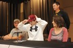 Aaron Kincaid, center, Prairie Grove senior, signs Thursday to play baseball for the University of Arkansas while his father, Chris, left; mother, Bonnie; and Prairie Grove coach Mitch Cameron watch during a ceremony at the school. Kincaid will join fellow Tiger Jalen Beeks on the Razorback roster. 
