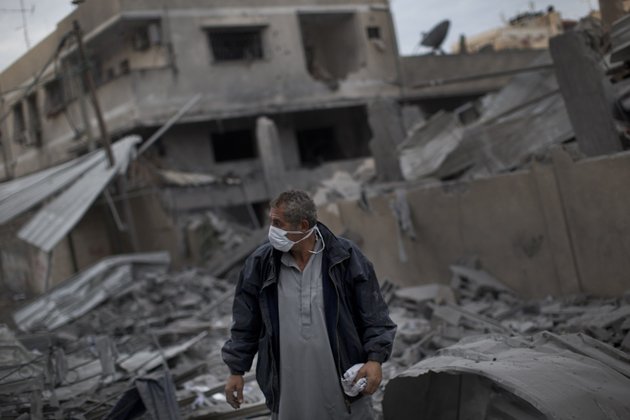 a-palestinian-man-walks-among-debris-after-an-israeli-airstrike-at-hamas-prime-minister-ismail-haniyehs-office-right-in-gaza-city-saturday-nov-17-2012-israel-bombarded-the-hamas-ruled-gaza-strip-with-more-than-180-airstrikes-early-saturday-widening-a-blistering-assault-on-militant-operations-to-target-government-and-police-compounds-and-a-vast-network-of-smuggling-tunnels