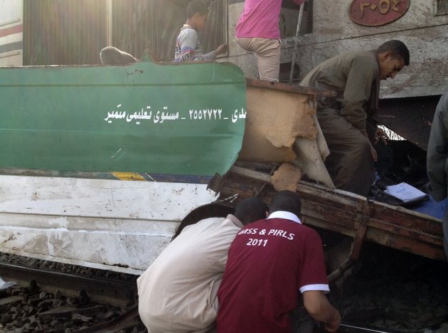 egyptians-inspect-the-wreckage-after-a-speeding-train-crashed-into-a-bus-carrying-children-to-their-kindergarten-in-southern-egypt-on-saturday-killing-at-least-47-officials-said-near-assiut-in-southern-egypt-saturday-nov-17-2012-the-bus-was-carrying-more-than-50-children-between-4-and-6-years-old-when-it-was-hit-near-al-mandara-village-in-manfaloot-district-in-the-province-of-assiut-a-security-official-said-adding-that-it-appears-that-the-railroad-crossing-was-not-closed-as-the-train-sped-toward-it