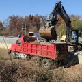 Workers with Dirt Co. haul away the foundation Wednesday of a former warehouse on Johnson Road in Jo...