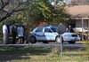 Benton County Prosecutor Van Stone and Bentonville police investigators stand outside a house on Southeast A Street, Tuesday, Nov. 20, 2012, after a missing 6-year-old girl's body was discovered. The girl was reported missing at 6:43 a.m. that morning.