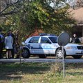 Benton County Prosecutor Van Stone and Bentonville police investigators stand outside a house on Sou...