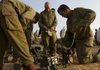Israeli soldiers prepare their ammunition Monday in a staging area near the Israel-Gaza Strip border in southern Israel. The Palestinian civilian death toll mounts as Israel pursues Gaza Strip militants who have been firing rockets into Israel. 
