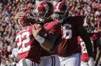 Alabama quarterback AJ McCarron (10) hugs teammate Alabama wide receiver Christion Jones (22) after throwing him a 29 yard touchdown pass during the first half of an NCAA college football game against Western Carolina at Bryant-Denny Stadium in Tuscaloosa, Ala., Saturday, Nov. 17, 2012. At right is Alabama offensive lineman D.J. Fluker (76). (AP Photo/Dave Martin)