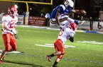 North Little Rock running back Altee Tenpenny jumps over Cabot defensive back Jordan Burke during the Charging Wildcats’ 28-0 victory in the Class 7A quarterfinals Friday night in North Little Rock. Tenpenny, who rushed for 141 yards in Friday’s victory, was penalized on the play for hurdling. 