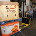 Dennis Morris (above) with Northwest Arkansas Food Bank loads a truck on Tuesday with food items for...