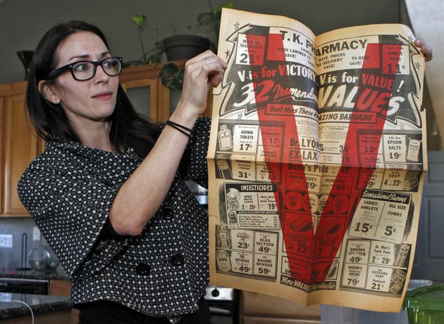 in-this-photo-taken-tuesday-nov-20-2012-alissa-williams-holds-up-a-an-advertising-flyer-from-tk-pharmacy-at-her-home-in-denver-the-flyer-from-the-early-1940s-was-found-with-other-documents-and-letters-during-renovations-at-a-former-denver-pharmacy-owned-by-japanese-americans