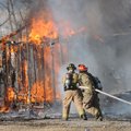 Shawn Rogers, left, and Aaron Box, Rogers firefighters, extinguish a storagebuilding fire Tuesday ne...