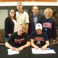 Lane Brand, seated left, and Gage Crosby, Bentonville swimmers, sign their national letters of inten...