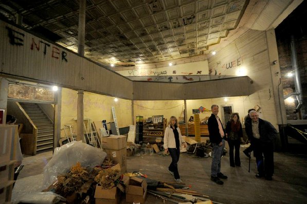 
                               
                                  Photo by Michael Woods&mdash;
                               
                           
                           Visitors take a look around the old opera house on the second floor of the old Dixieland shoe store on the corner of Walnut and 1st street in Rogers Wednesday morning.  John Mack, owner of JKJ Architects, recently purchase the former Dixieland Shoe store. He is restoring the building which includes the Opera House on the second floor, once a grand theater.