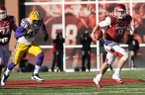 NWA Media/ANDY SHUPE -- Arkansas quarterback Tyler Wilson scrambles with the football while being pursued by LSU defensive end Barkevious Mingo (49) during the second quarter of play Friday, Nov. 23, 2012, at Razorback Stadium.