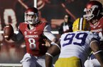 Arkansas quarterback Tyler Wilson (8) passes over LSU defensive end Sam Montgomery (99) as Arkansas offensive tackle Brey Cook, right, defends during the second quarter of an NCAA college football game in Fayetteville, Ark., Friday, Nov. 23, 2012.