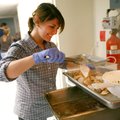 Ashley Evilsizor moves pieces of turkey to a tray at Charity Baptist Church on Thursday in Rogers. F...