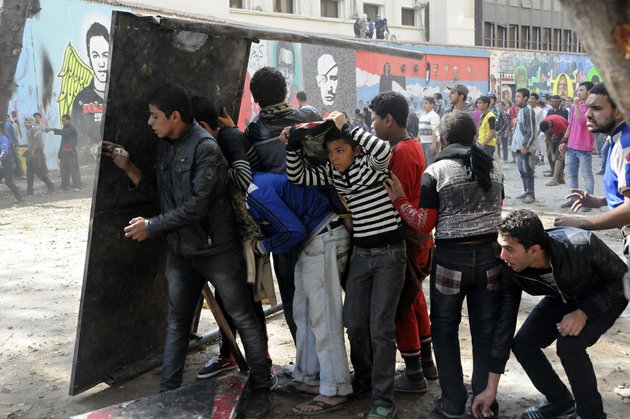 egyptian-protesters-opposed-to-president-mohammed-morsi-take-cover-during-clashes-with-morsi-supporters-near-tahrir-square-in-cairo-on-friday-nov-23-2012