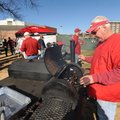 Mike Moffett of Fayetteville checks on a piece of meat he was smoking Friday while tailgating with f...
