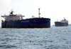 Finaval SpA’s Neverland Dream oil tanker (left) is seen in Singapore, Asia’s largest oil-trading-and-storage center. Customs data show Iranian oil shipments to Asia have increased since the West tightened sanctions in July. 