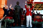 Former Arkansas Coach and Athletic Director Frank Broyles calls the Hogs on Friday during a ceremony unveiling a statue in his honor outside the Broyles Athletic Center in Fayetteville.