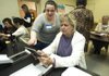 Emma Santoy (left), an employee with Barnes & Noble, helps Suzzette Patterson use a Nook ereader. 