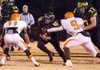 Prairie Grove running back Weston Bartholomew (center) runs the ball as offensive lineman Jacob Lacey blocks Nashville’s Kyler Lawrence (right) during Friday’s Class 4A quarterfinal game in Prairie Grove. 