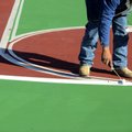 Jose Chavez paints striping on the new basketball court surface Thursday at Polo Square Apartments i...