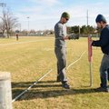 Christopher Ferguson, (above) left, holds back a rope Thursday used as a height guide as David Henso...