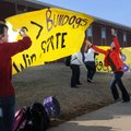 Rainy Bray, center, Bentonville High School freshman, has a gust of wind pull a sign out of her hand...