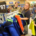 Gena Whittenburg, center, of Fayetteville, helps her son Tobey, 6, pick out a new hoodie Friday with...