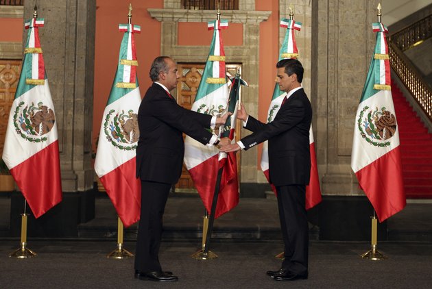 in-this-image-released-by-the-press-office-of-president-elect-enrique-pena-nieto-on-saturday-dec-1-2012-mexicos-outgoing-president-felipe-calderon-left-gives-a-mexican-flag-to-president-elect-enrique-pena-nieto-during-the-official-transfer-of-command-ceremony-at-the-national-palace-in-mexico-city-saturday-dec-1-2012-pena-nieto-will-be-officially-sworn-in-as-mexicos-new-president-during-a-ceremony-at-the-national-congress-later-on-saturday