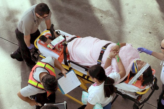emergency-personnel-attend-to-injured-passengers-after-a-bus-accident-at-miami-international-airport-on-saturday-dec-1-2012-in-miami-officials-say-a-bus-has-hit-an-overpass-killing-at-least-one-person-and-injuring-more-than-two-dozen-people-on-board-airport-spokesman-greg-chin-says-the-large-white-bus-hit-the-overpass-going-into-the-airports-arrivals-section-on-saturday-morning-the-bus-was-going-about-20-mph-when-it-clipped-the-roof-entrance