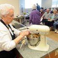 Kaye Burns adds eggs to cookie dough Friday while leading a cooking demonstration of Christmas hors ...