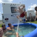 Ted Georges, of Columbus, Ohio, jumps into a pool from the top of a recreational vehicle parked in t...