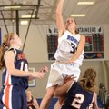McKinzie James, Rogers High, takes the ball to the basket Saturday over Rogers Heritage’s Ashley War...